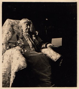 Photo of an old woman sitting in a chair